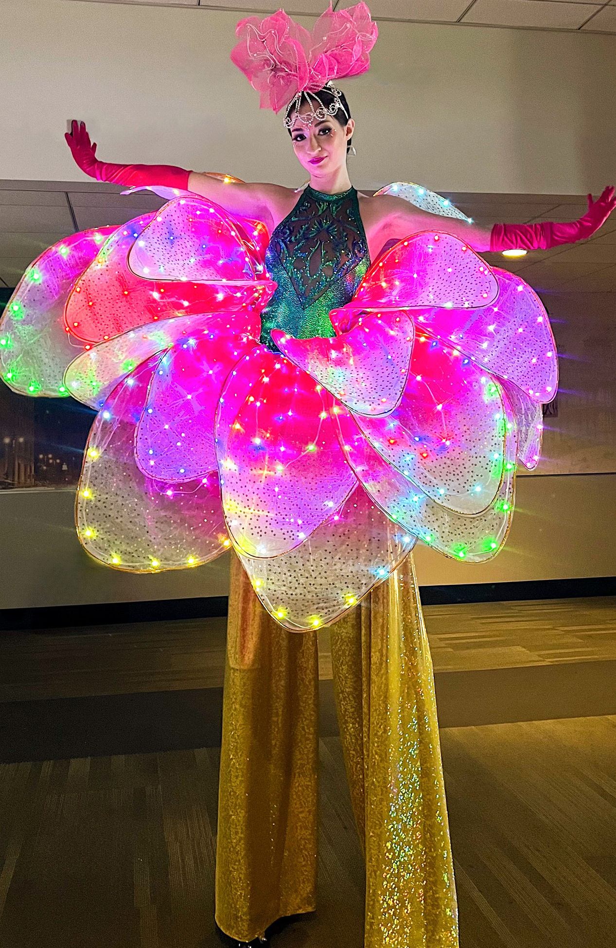 LED flower stilt walker entertaining guests at a children's event